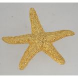 A vintage signed gold tone figural brooch in the form of a starfish with texture body and roller