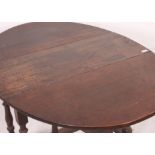 A 1920's oak drop leaf dining table raised on barley twist legs with drop leaves of oval shape.