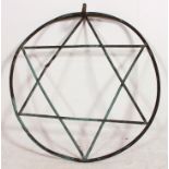 A large 20th century cast metal garden wall sculpture in the form of a star within circle,