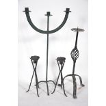 A wrought iron three branch candelabra along with a pair of 20th Century cast iron candlesticks of