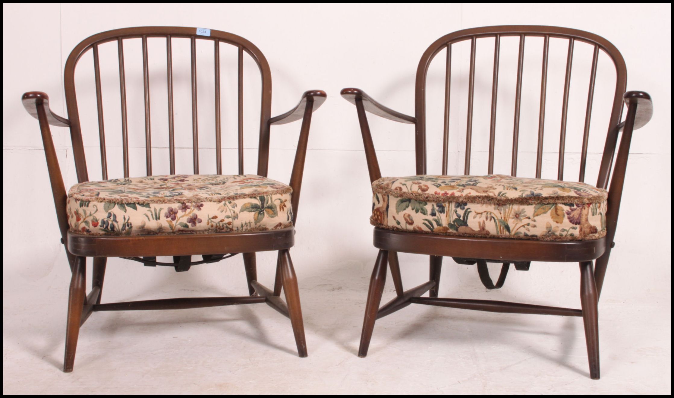 A pair of Ercol beech and elm windsor pattern armchairs complete with the cushions.