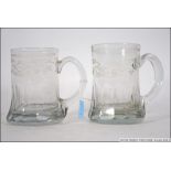 A pair of early 19th century cut and acid etched continental glass tankards with scroll handles