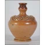 A Doulton stoneware glazed miniature vase with brown glaze and embellished finish with chasing and