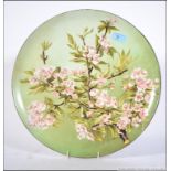 A stunning hand painted wall charger heavily decorated with floral sprays. Measures: 41cms wide.