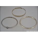 A group of 3 white metal bracelets / ban