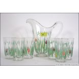 A vintage 1930s lemonade set consisting of jug and six glasses with hand painted tulip design.