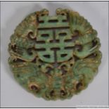 A Chinese Jade roundel of carved form with central geometric design surrounded by Bats.