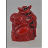 A Chinese oriental carved coral buddha figure depicted counting money. Measures: 4cms high.