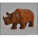 A carved hardwood netsuke in the form of a rhinoceros. Measures: 6cms long.