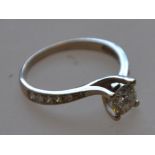 A 585 marked 14ct white gold solitaire ring with diamond encrusted shoulders and central stone