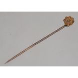 A Victorian 9ct gold and diamond inset stick / hat pin with flower head top. Total weight 1.