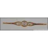 A 9ct gold and diamond bar brooch with central stone approx 10pnts with floral inset surround,