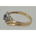 A 9ct gold, sapphire and diamond ladies ring. The teardrop sapphire surrounded by .