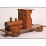 A 20th century vintage scratchbuilt large wooden sit on - pull along train with wheels.