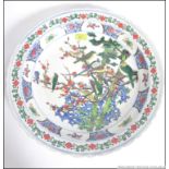 A large Chinese famille rose wall charger having handpainted design of birds and trees with scolled