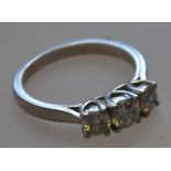 A hallmarked 18ct gold 3 stone diamond ring with trellis setting. approx 2x25pts and one 50pts 5.