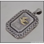 A Victorian silver locket of rectangular form with gilded bird being hallmarked for 1905,