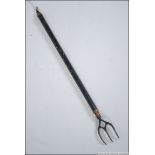 A 19th century metamorphic / telescopic brass ebonised toasting fork.