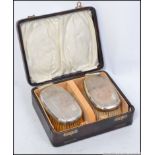 A pair of cased gentlemans silver hallmarked hair brushes,