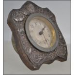 A silver hallmarked Art Nouveau desk clock having floral decoration in repose,