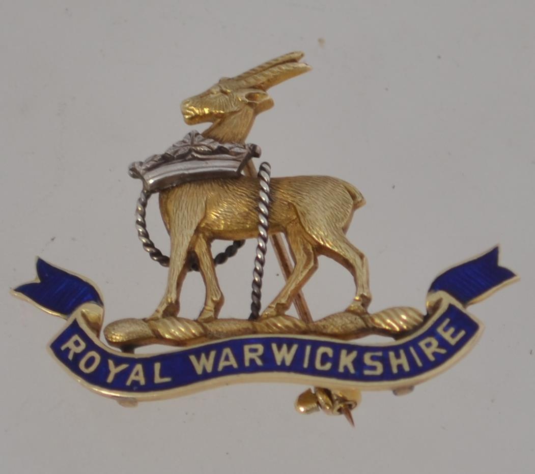 A rare Royal Warwickshire 14ct gold and enamel badge dating to the mid century having roll clasp