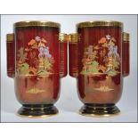 A pair of 1930's Crown Devon Fieldings decorative vases, rouge colour with twin handles,