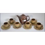 A Roger Cockram stoneware 6 person tea service to include 6 cups and saucers and a teapot.