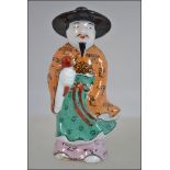 An Oriental ceramic figural scent bottle with character marks to the base H9cm