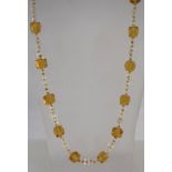 A 1920s flapper necklace with clear and topaz glass beads, measuring 109cms long.