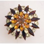 A large 1960s starburst cluster brooch in a gold tone setting with a rollover clasp,
