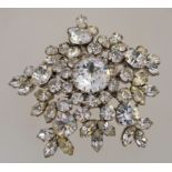 A large 1950s to 1960s rhinestone cluster brooch in a silver tone metal setting with a rollover