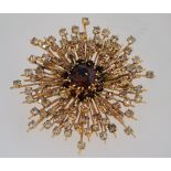 A large 1960s sunburst rhinestone brooch with the stones graduating from a dark topaz colour to