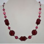 A 1930s art deco red pressed glass bead necklace, with a barrel clasp and its original stringing.