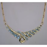 A 1970s pale blue rhinestone necklace in gold tone metal with a fold over clasp,