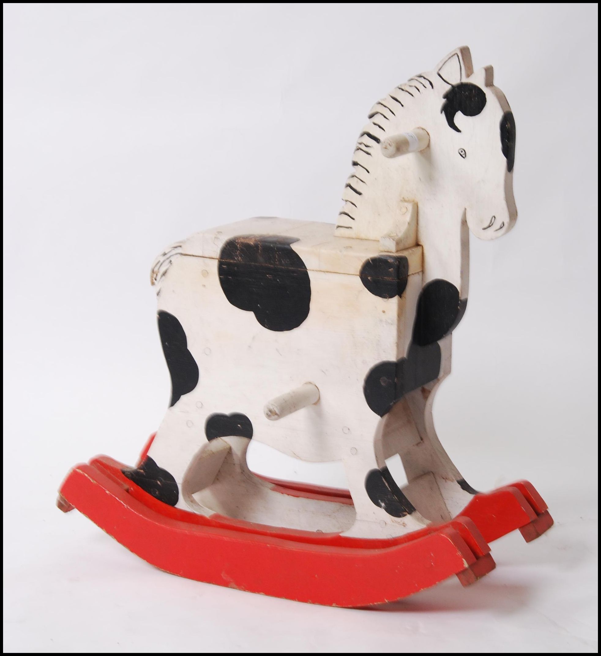 A 1950's unusual painted rocking horse of small proportions set over red painted wood glider rails