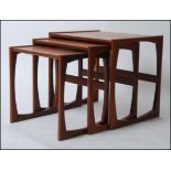 A 1970's G-Plan Kelso pattern retro teak wood nest of tables raised on shaped supports with