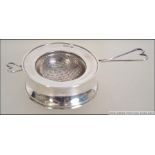 A silver hallmarked tea strainer with heart shaped handle Birmingham assay marks together with a
