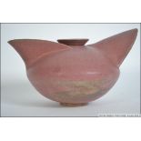 A stylised studio pottery dark pink earthenware teapot of unusual form from Devon having impressed