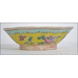 A 19th century Chinese porcelain bowl of lobed form being decorated with stylised foliates on a