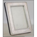 A silver hallmarked miniature picture frame with velour easel backed.