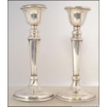 2 silver hallmarked candlesticks, each with terraced bases having single sconces.