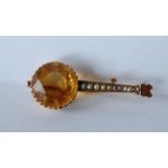 A 9ct gold Victorian brooch pin in the form of a Banjo with large prong set yellow tourmaline,