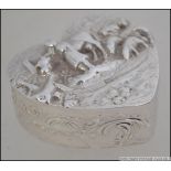 A silver hallmarked pill box in the form of a heart having unusual farming scene cast in relief to