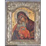 An orthodox Russian Icon depicting The Virgin Mother and Child within a stylistic silver plate