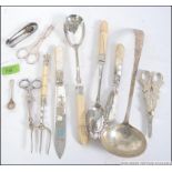 A collection of silver hallmarked and silver flat wares to include pickle fork, ladel, sugar nips,
