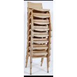 A set of 8 vintage mid century stacking school chairs raised on angled frames with panel seat and