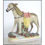 A 19th century Staffordshire figurine flat back of a donkey being raised on a plinth base.