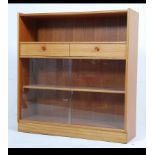 A mid 20th century teak wood display cabinet / bookcase by Nathan having a pair of glazed sliding