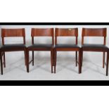 A set of four retro teak wood Danish inspired dining chairs raised on tapering legs united by
