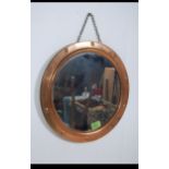 A vintage mid 20th century brass porthole style wall mirror with stud affect surround and metal